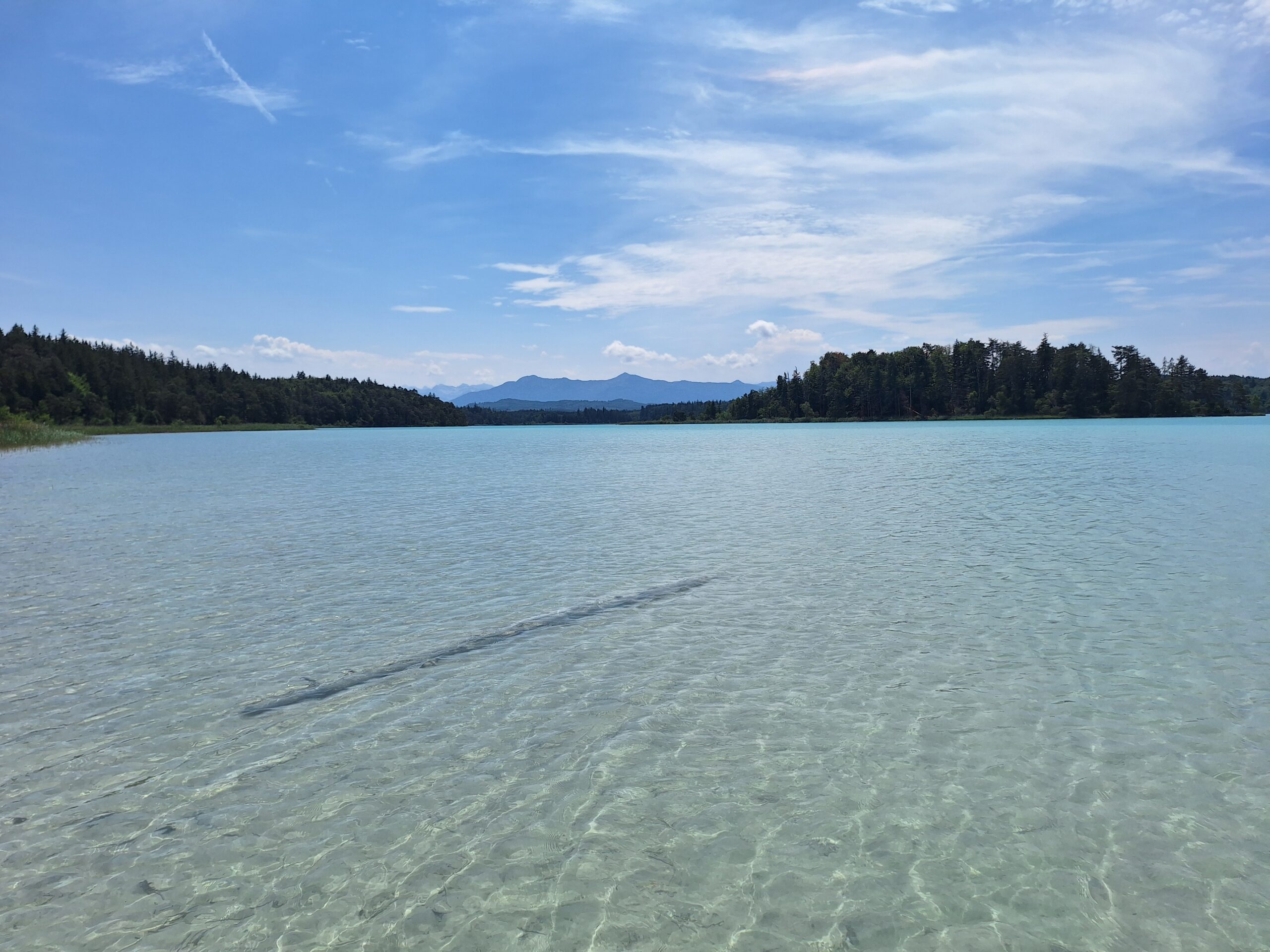 Blick über den See zu den Bergen bei blauem Himmel